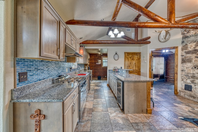 kitchen featuring gas range, backsplash, beam ceiling, a towering ceiling, and sink