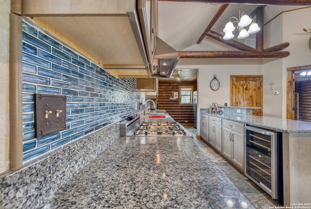 kitchen with stone counters, backsplash, beverage cooler, tile floors, and a chandelier