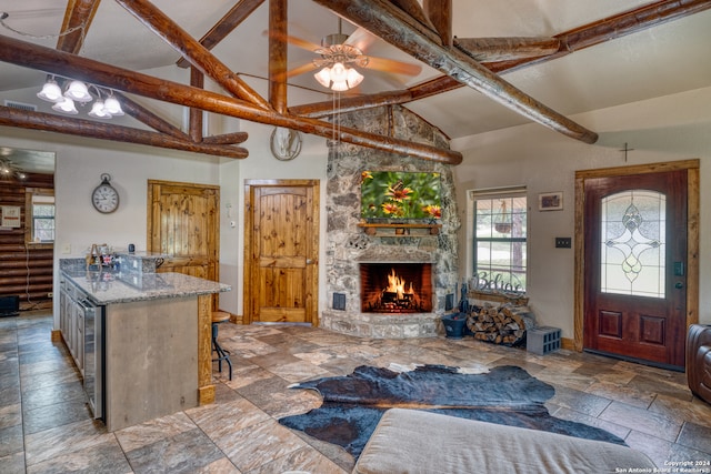 living room with tile floors, beam ceiling, ceiling fan, and a fireplace