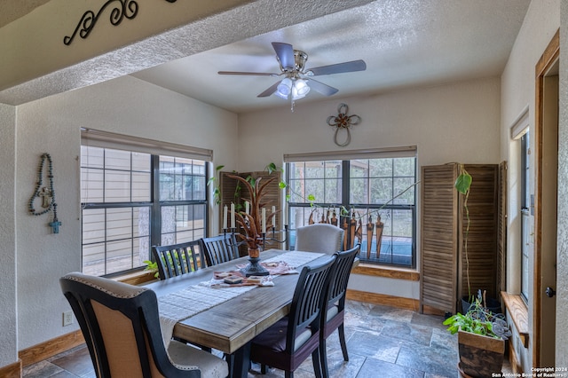 tiled dining room with a textured ceiling and ceiling fan