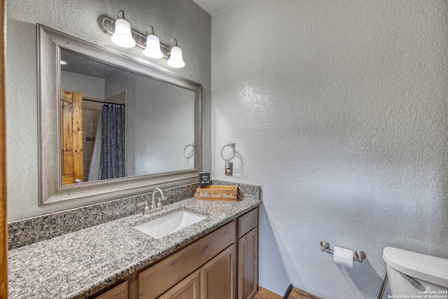 bathroom featuring oversized vanity and toilet