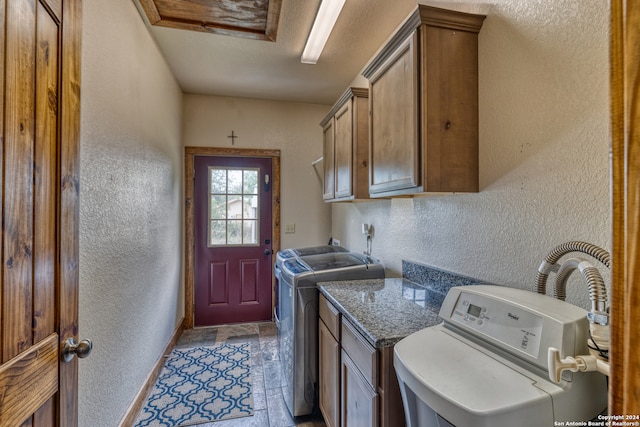 clothes washing area with cabinets, independent washer and dryer, and light tile floors