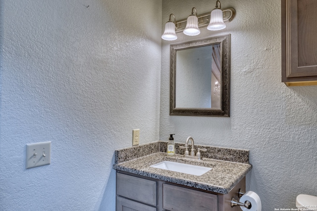 bathroom with vanity with extensive cabinet space and toilet