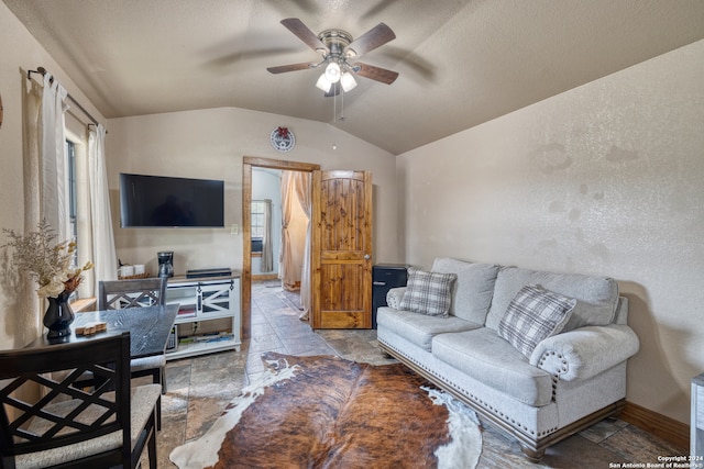 living room featuring vaulted ceiling, ceiling fan, and tile flooring