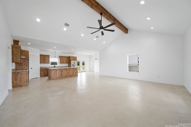 unfurnished living room with beam ceiling, high vaulted ceiling, and ceiling fan