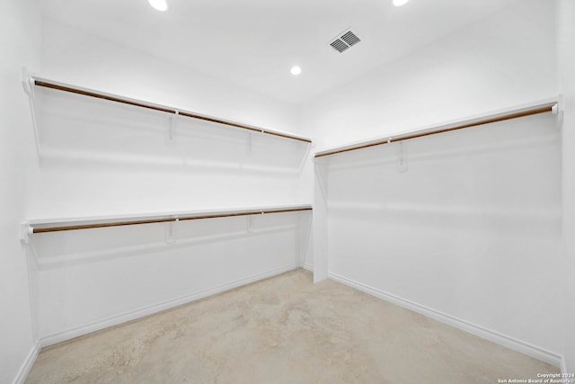 walk in closet with light colored carpet