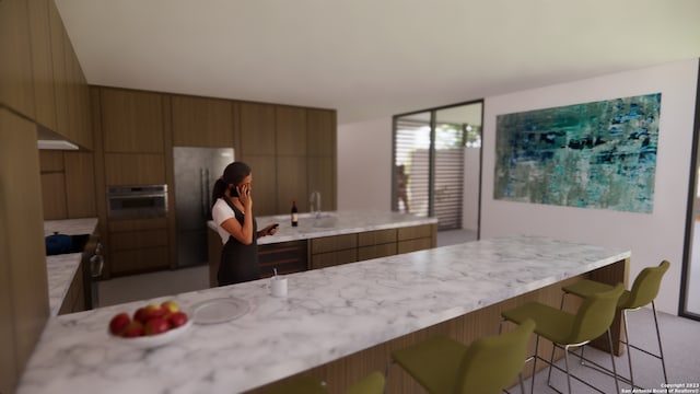 kitchen featuring black refrigerator, stove, stainless steel oven, and a kitchen bar