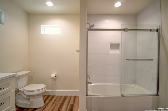 full bathroom featuring enclosed tub / shower combo, toilet, vanity, and hardwood / wood-style floors