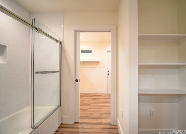 bathroom featuring shower / bath combination with glass door and hardwood / wood-style floors