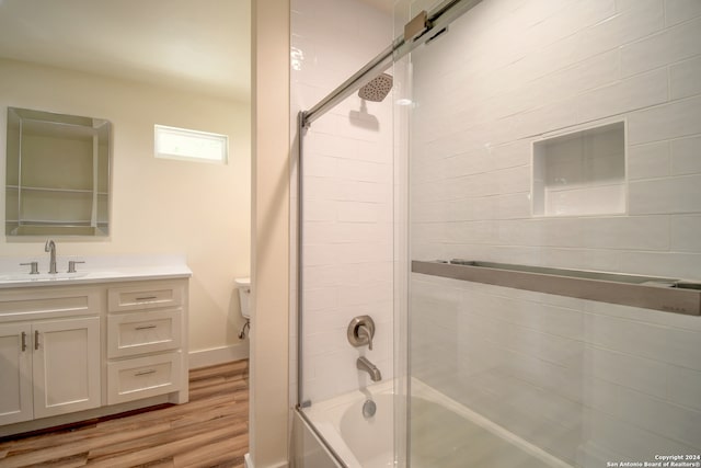 full bathroom featuring enclosed tub / shower combo, toilet, vanity, and hardwood / wood-style floors