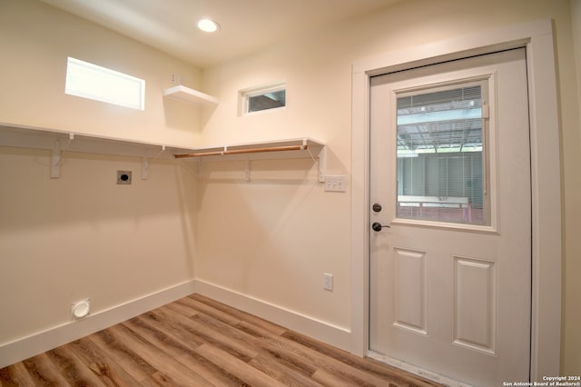 interior space featuring hookup for an electric dryer, light hardwood / wood-style floors, and a wealth of natural light