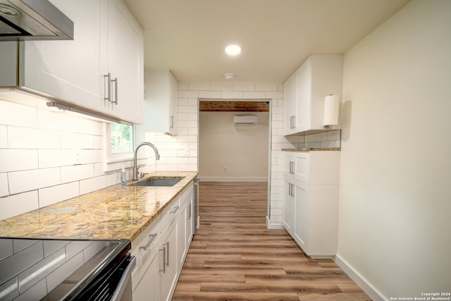 kitchen featuring backsplash, sink, white cabinetry, and extractor fan