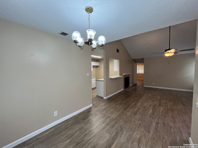 spare room with ceiling fan with notable chandelier, a textured ceiling, dark wood-type flooring, and vaulted ceiling