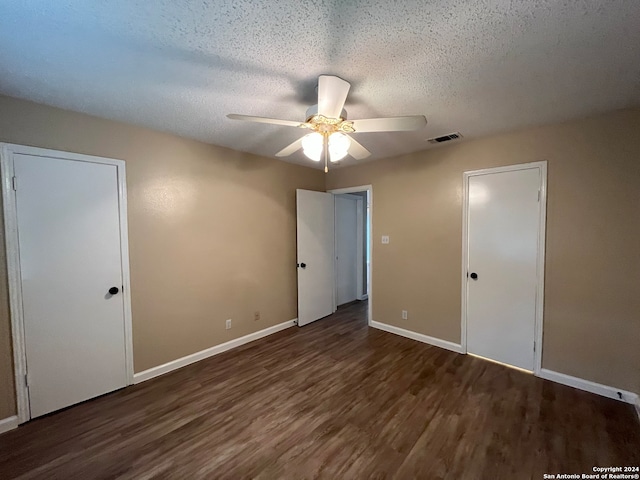 unfurnished bedroom with ceiling fan, dark wood-type flooring, and a textured ceiling