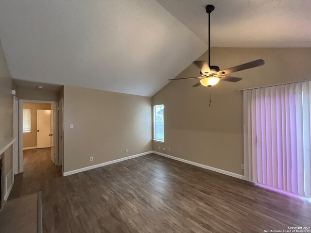 spare room with dark wood-type flooring, ceiling fan, and vaulted ceiling