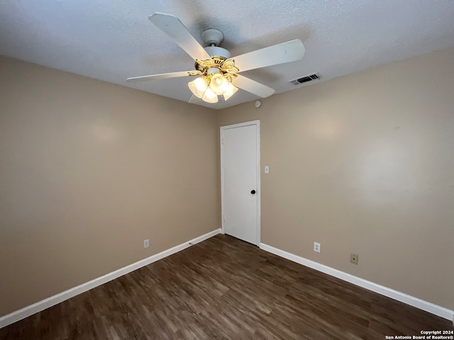 spare room with a textured ceiling, ceiling fan, and dark hardwood / wood-style flooring