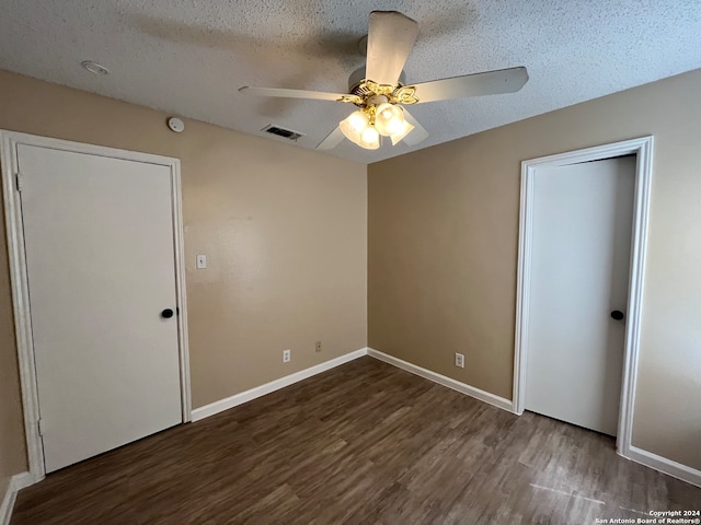 unfurnished bedroom featuring dark wood-type flooring, ceiling fan, and a textured ceiling