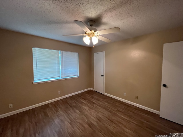 unfurnished room with dark hardwood / wood-style flooring, ceiling fan, and a textured ceiling