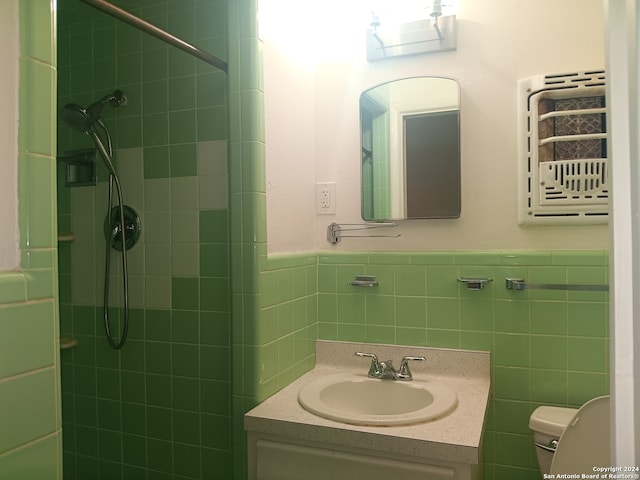 bathroom with toilet, vanity with extensive cabinet space, and a tile shower