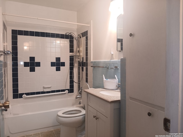 full bathroom featuring tiled shower / bath combo, oversized vanity, tile floors, and toilet