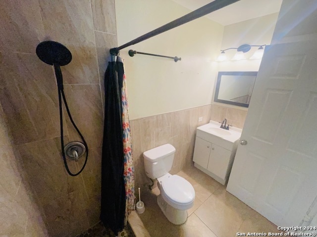 bathroom with tile walls, toilet, tile flooring, a shower with curtain, and vanity