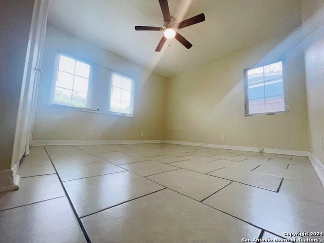 spare room featuring tile flooring and ceiling fan