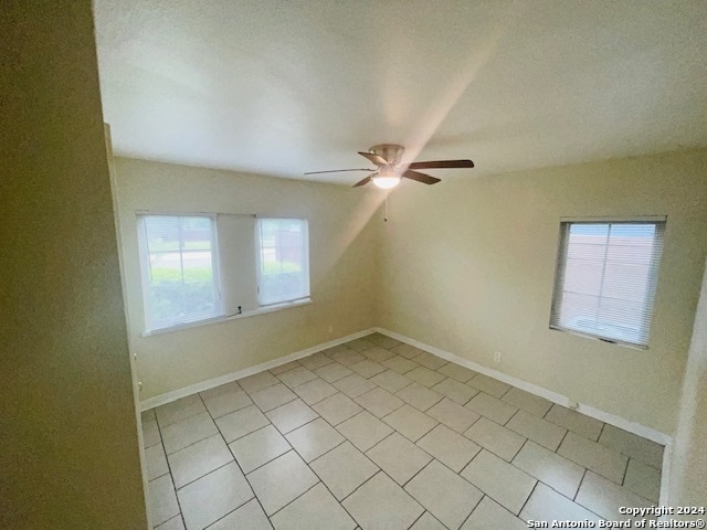 tiled empty room with ceiling fan