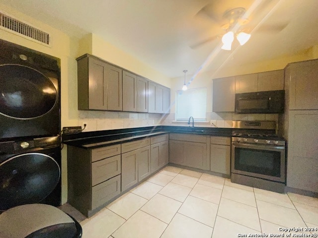 kitchen featuring stacked washer and clothes dryer, ceiling fan, backsplash, and stainless steel gas stove