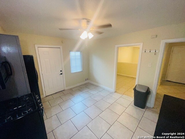 interior space with ceiling fan and light tile floors