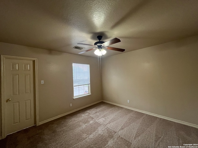 spare room with ceiling fan, carpet, and a textured ceiling