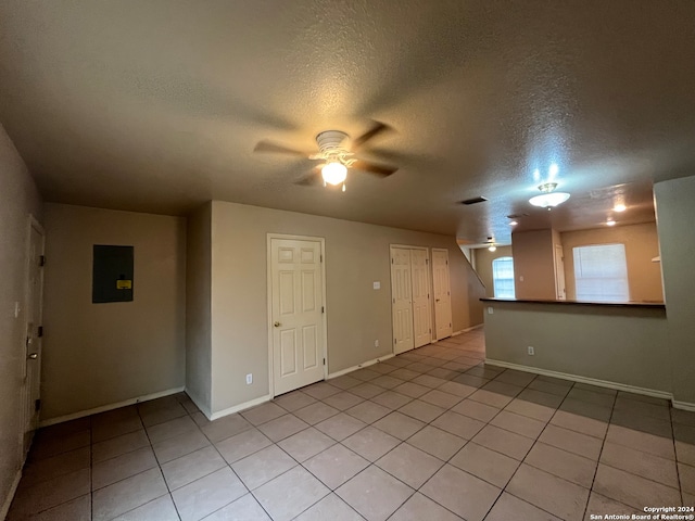 tiled empty room featuring a textured ceiling and ceiling fan