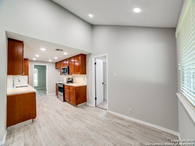 kitchen with backsplash, a wealth of natural light, stainless steel appliances, and sink