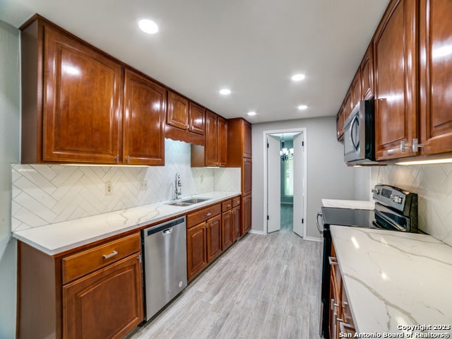 kitchen featuring light hardwood / wood-style flooring, sink, stainless steel appliances, and tasteful backsplash