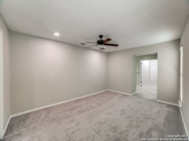 carpeted spare room featuring ceiling fan