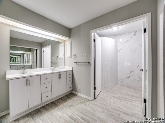 bathroom with hardwood / wood-style flooring and double vanity