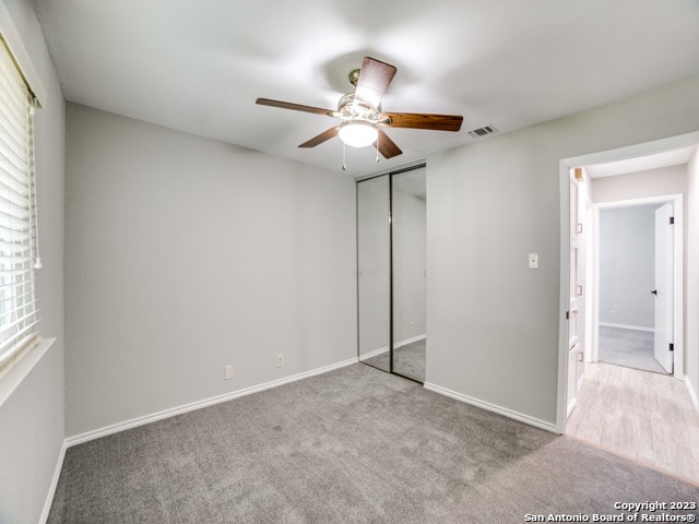 unfurnished bedroom with a closet, ceiling fan, and carpet floors