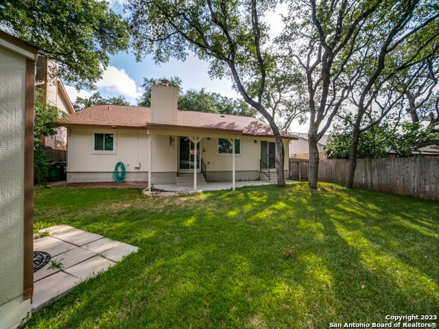 back of property featuring a lawn and a patio area