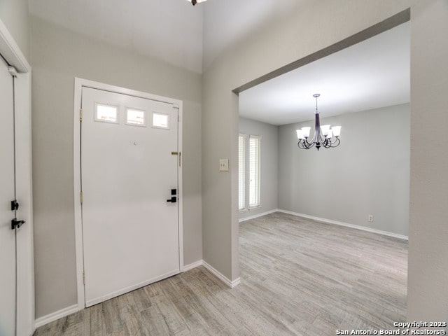 foyer entrance featuring light hardwood / wood-style floors and an inviting chandelier