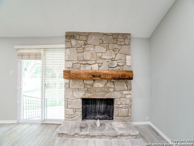 unfurnished living room with light hardwood / wood-style floors and a stone fireplace