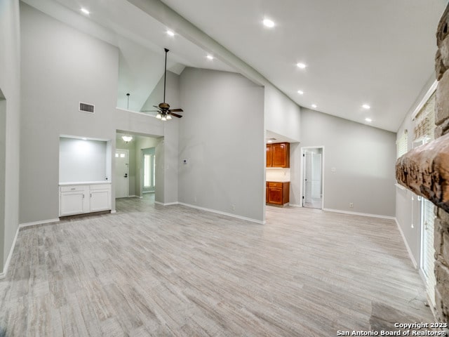 unfurnished living room featuring high vaulted ceiling, light hardwood / wood-style floors, and ceiling fan