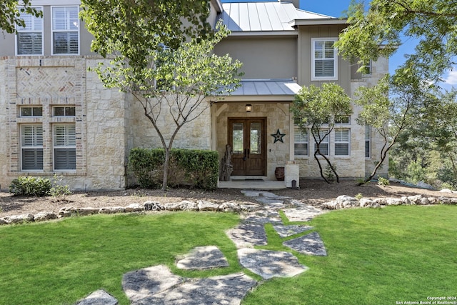 view of front of home with a front lawn and french doors