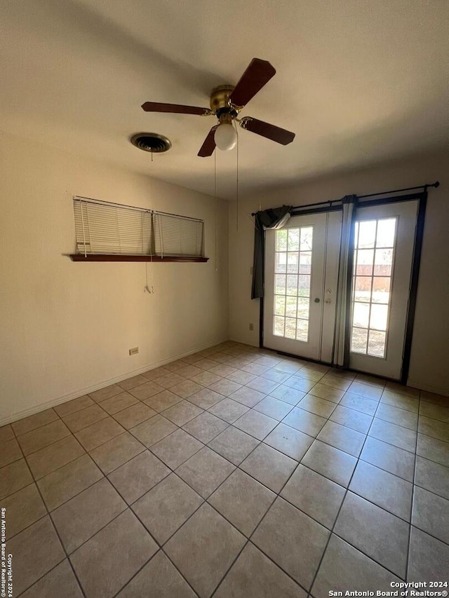 spare room featuring tile floors and ceiling fan