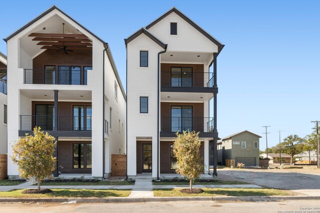 modern home with a balcony and a front lawn