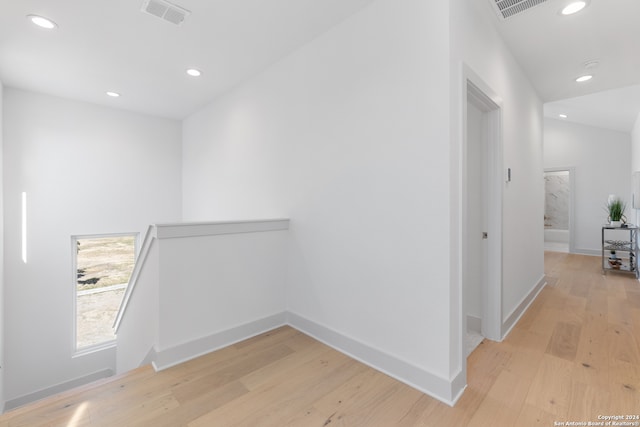 hall featuring vaulted ceiling and light hardwood / wood-style floors