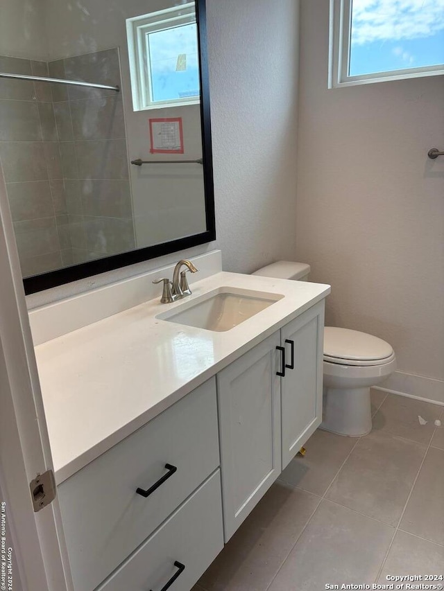 bathroom featuring vanity, tile patterned flooring, toilet, and plenty of natural light