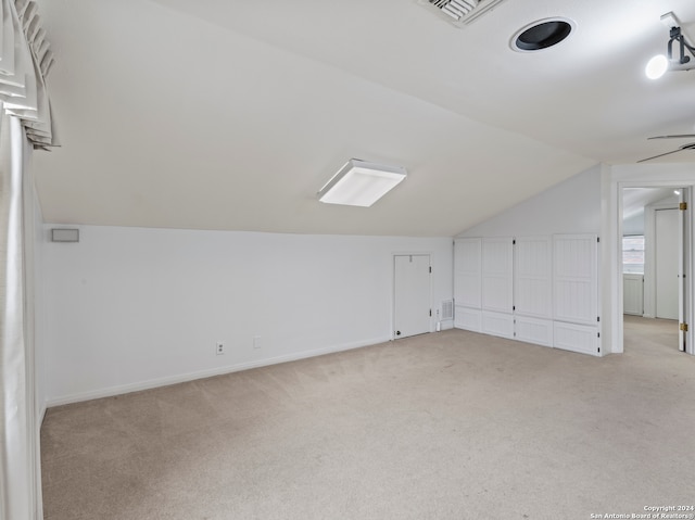 bonus room featuring vaulted ceiling and light colored carpet