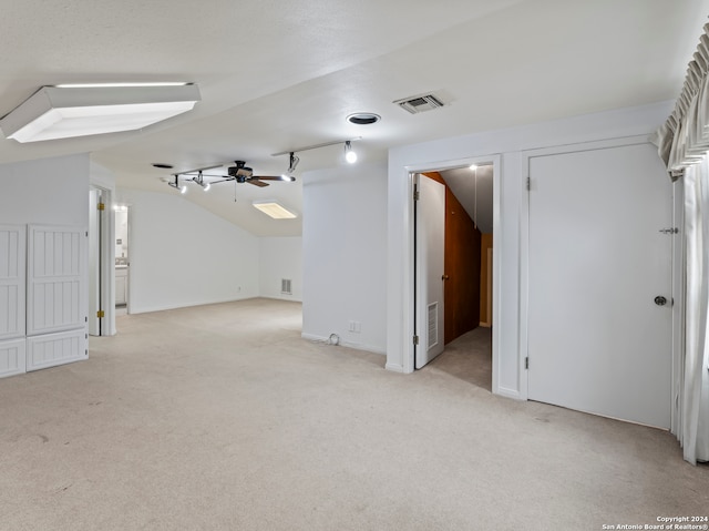 interior space featuring lofted ceiling, light carpet, and ceiling fan