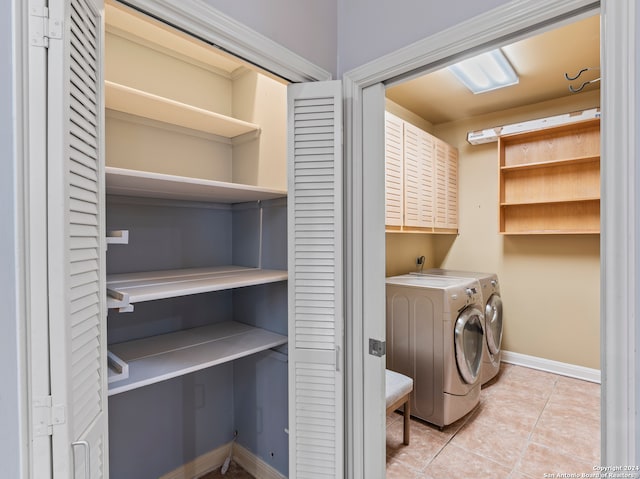 washroom featuring light tile patterned flooring, separate washer and dryer, and cabinets