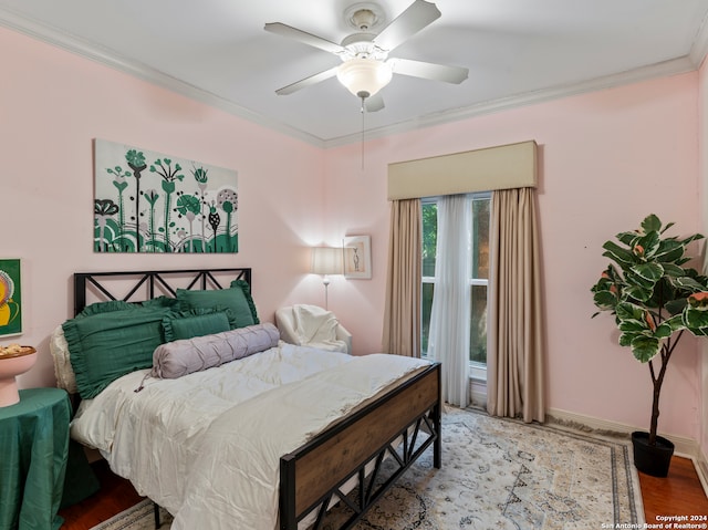 bedroom featuring light hardwood / wood-style floors, crown molding, and ceiling fan