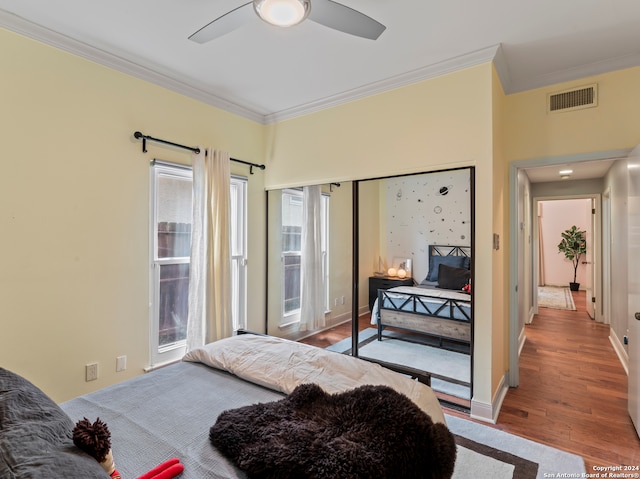 bedroom with hardwood / wood-style flooring, crown molding, and ceiling fan